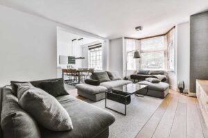 Homeowner reviewing documents beside a clean living room while preparing a property for sale.