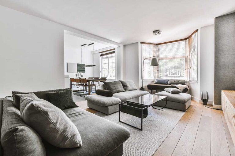 Homeowner reviewing documents beside a clean living room while preparing a property for sale.